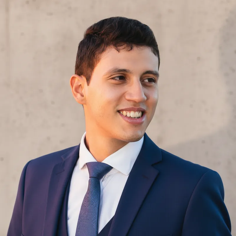 Generated headshot of a man in a navy suit and tie, warm neutral studio lighting